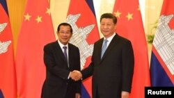 FILE - Cambodia’s Prime Minister Hun Sen shakes hands with China's President Xi Jinping before their meeting at the Great Hall of the People in Beijing, China April 29, 2019. (Madoka Ikegami/Pool via REUTERS) 