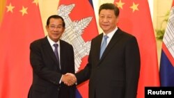 រូបឯកសារ៖ លោកនាយករដ្ឋមន្ត្រី ហ៊ុន សែន ចាប់ដៃ​ជាមួយ​លោក​ប្រធានាធិបតីចិន ស៊ី ជីនពីង មុន​កិច្ចប្រជុំនៅវិមានរដ្ឋាភិបាលចិនប្រចាំទីក្រុង​ប៉េកាំង ប្រទេស​ចិន ថ្ងៃទី២៩ ខែមេសា ឆ្នាំ២០១៩។ 