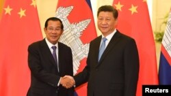 រូបឯកសារ៖ លោកនាយករដ្ឋមន្ត្រី ហ៊ុន សែន ចាប់ដៃ​ជាមួយ​លោក​ប្រធានាធិបតីចិន ស៊ី ជីនពីង មុន​កិច្ចប្រជុំនៅវិមានរដ្ឋាភិបាលចិនប្រចាំទីក្រុង​ប៉េកាំង ប្រទេស​ចិន ថ្ងៃទី២៩ ខែមេសា ឆ្នាំ២០១៩។ 