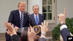 Wartawan mengangkat tangan mereka, menunggu giliran untuk mengajukan pertanyaan kepada Presiden Donald Trump dan Pemimpin Mayoritas Senat AS, Mitch McConnell dari Kentucky, di Taman Mawar Gedung Putih, Senin, 16 Oktober 2017. (AP Photo / Pablo Martinez Monsivais)