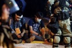 Police interrogate protesters who left the occupied campus of the Hong Kong Polytechnic University that is surrounded by police in Hong Kong, China, Nov. 18, 2019.