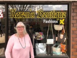 Karen Prohaska, 76, stands outside her purse-and-jewelry shop in Plattsmouth, Neb., Nov. 9, 2020. Prohaska says she hopes not to get the virus, but she usually doesn't wear a mask in her store.