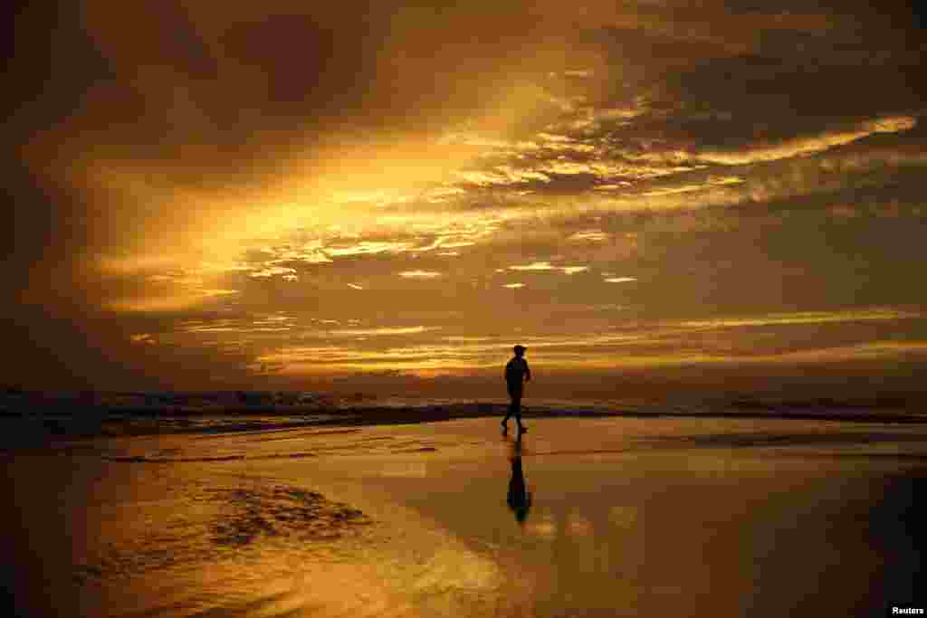 Matthew Walker walks on the beach as Hurricane Michael approaches Panama City Beach, Florida, Oct. 9, 2018. 