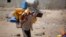 FILE - A boy carries buckets to fill with water from a public tap amid an acute shortage of water Oct. 13, 2015, on the outskirts of Sanaa, Yemen.
