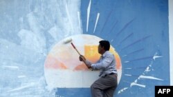 រូបឯកសារ៖ អ្នកគាំទ្រគណបក្សសង្គ្រោះជាតិម្នាក់លាបថ្នាំពី​លើ​ស្លាកសញ្ញាគណបក្សនេះនៅឯទីស្នាក់ការគណបក្សក្នុងរាជធានីភ្នំពេញ ​កាល​ពី​ថ្ងៃទី១៨ ខែវិច្ឆិកា ឆ្នាំ២០១៧។ 