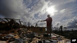 Jose Garcia Vicente holds a piece of plumbing he picked up, as he shows his destroyed home, in the aftermath of Hurricane Maria, in Aibonito, Puerto Rico, Monday, Sept. 25, 2017.
