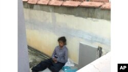 Pembantu rumah tangga asal Indonesia Adelina Lisao duduk di teras di Bukit Mertajam, dekat Penang, Malaysia. (Foto: AP)