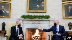 President Joe Biden, right, gestures during a meeting with German Chancellor Olaf Scholz in the Oval Office of the White House, in Washington, Feb. 7, 2022.