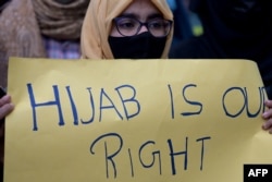 A woman protests after students at government-run high schools in India's Karnataka state were told not to wear hijabs in the premises of the institute, in New Delhi, Feb. 8, 2022.