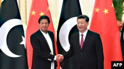 Presiden China Xi Jinping (kanan) berjabat tangan dengan Perdana Menteri Pakistan Imran Khan sebelum melakukan pertemuan di Beijing, pada 28 April 2019. (Foto: Pool/AFP/Madoka Ikegami)