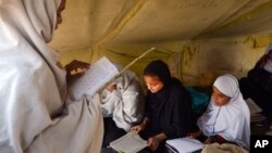 FILE - Afghan students attend class in a tent in Jalalabad, capital of Nangarhar province, Afghanistan, Dec. 16, 2015.