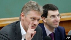 FILE - Russian President Vladimir Putin's spokesman Dmitry Peskov, left, speaks during a meeting in Moscow, Russia, Dec. 9, 2012. 