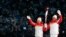 Chinese torchbearer athletes Dinigeer Yilamujian (L) and Zhao Jiawen hold the Olympic flame during the opening ceremony of the Beijing 2022 Winter Olympic Games, Feb. 4, 2022.