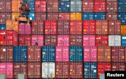 Seorang pekerja berjalan di atas tumpukan kontainer di Pelabuhan Tanjung Priok, Jakarta, 22 Januari 2021. (Foto: REUTERS/Ajeng Dinar Ulfiana)