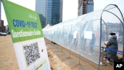 People wait for their coronavirus test at a makeshift testing site in Seoul, South Korea, Monday, Feb. 7, 2022. (AP Photo/Ahn Young-joon)