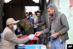 Afghans wait to receive food rations organized by the World Food Program (WFP) in Pul-e-Alam, the capital of Logar province. eastern of Afghanistan, Jan. 18, 2022.