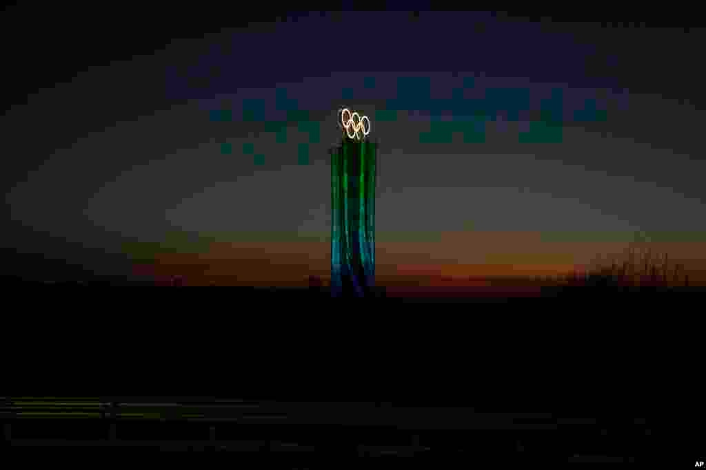 The Olympic rings are lit up along a road Feb. 1, 2022, in the Yanqing district of Beijing.