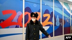 资料照片：在2022年北京冬季奥运会开幕前，一名中国安保人员在张家口太子城站的“闭环管理”“泡泡”区域内引导到达的乘客。（2022年1月29日）