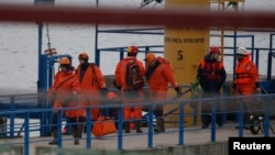 Russian Emergencies Ministry members walk on a pier near the crash site of Russian military Tu-154 plane in the Black Sea in the Sochi suburb of Khosta, Russia, Dec. 25, 2016. 