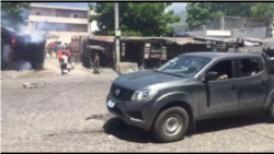 A gray pickup truck with armed men wearing police uniforms who shot tear gas and rubber bullets at protesters.