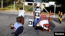 FILE - Mannequins depicting torture victims are left by demonstrators protesting against former Salvadoran army General Jose Guillermo Garcia prior to Garcia's arrival, at El Salvador International Airport in San Luis Talpa, Jan. 8, 2016. 