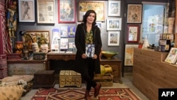 Tunisian cartoonist Nadia Khiari poses with her latest Willis book published in November showing a selection of her best work over the decade since the uprising, in the capital Tunis on December 12, 2020. (Photo by Fethi Belaid / AFP)