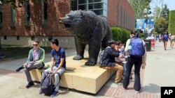 Mahasiswa berkegiatan di sekitar kampus Universitas California, Los Angeles, Jumat, 26 April 2019. Beberapa mahasiswa dan staf yang kemungkinan tertular campak di dua universitas di Los Angeles masih dikarantina di kampus atau diperintahkan pulang.
