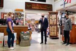 President Joe Biden speaks with Mary Anna Ackley, Owner of Little Wild Things Farm, left, and Michael Siegel, Co-owner of W.S. Jenks &amp; Son, right, March 9, 2021, in Washington.