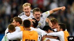 L'équipe allemande célèbre avec Julian Brandt, en haut à gauche, et Matthias Ginter, en haut à droite, après avoir remporté le match de football de la Coupe des Confédérations entre le Chili et l'Allemagne, au Stade de Saint-Pétersbourg, Russie, 2 juillet 2017. 