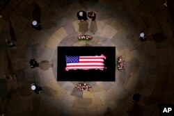 ປະທານາທິບໍດີທີ່ຖືກເລືອກ ທ່ານ ດໍໂນລ ທຣໍາ ແລະ ທ່ານນາງ ເມີລາເນຍ ທຣໍາ ຢຶນສະຫງົບເພື່ອໄວ້ອາໄລໃຫ້ແກ່ຫີບສົບທີ່ປົກດ້ວຍທຸງຊາດຂອງອະດີດປະທານາທິບໍດີ ຈິມມີ ຄາຣ໌ເຕີ ຂະນະທີ່ດອຍໄວ້ຢູ່ ໂຣທັນດາ ຂອງຫໍລັດຖະສະພາແຫ່ງຊາດໃນນະຄອນຫຼວງວໍຊິງຕັນ, ວັນທີ 8 ມັງກອນ 2025.