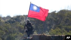 资料照：一名台湾士兵手举台湾旗帜参加新竹举行的军演模拟反击中国军队攻台。（2021年1月19日）