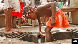 Un enfant angolais se lave près d'une pompe à eau à Luanda, en Angola le 9 février 2007.