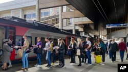Passengers at a railway station in Minsk, Belarus, stand in line to board a high-speed train to Moscow on May 28, 2021.