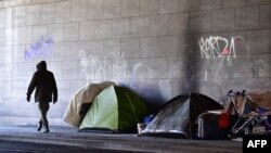Un homme passe devant des tentes dans un campement improvisé des sans-abris dans le quartier de Tiergarten à Berlin, Allemagne, 1er mars 2018.