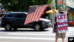 Erica Koesler of Los Angeles demonstrates outside a post office after the United States Postal Service warned that it cannot guarantee all ballots cast by mail for the November election will arrive in time to be counted, Aug. 15, 2020.