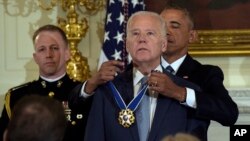 President Barack Obama presents Vice President Joe Biden with the Presidential Medal of Freedom during a ceremony in the State Dining Room of the White House in Washington, Jan. 12, 2017. 