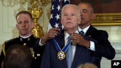 President Barack Obama presents Vice President Joe Biden with the Presidential Medal of Freedom during a ceremony in the State Dining Room of the White House in Washington, Jan. 12, 2017. 