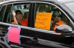 FILE - Motorists take part in a caravan protest asking for the extension of the $600 in unemployment benefits to people out of work because of the coronavirus in New Orleans, La., July 22, 2020.