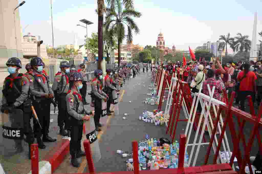 Protesters offer food and drinks to riot police during a rally against the military coup in Yangon, Myanmar, Feb. 7, 2021. (Credit: VOA Burmese Service)