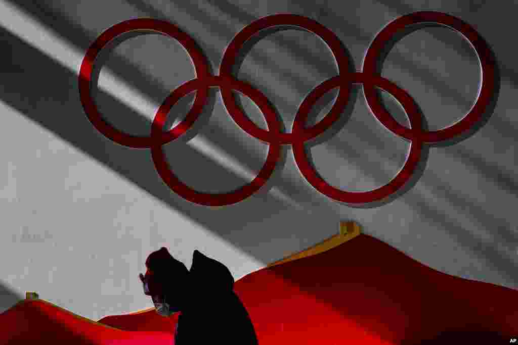 A man wearing a protective mask walks inside of the Zhangjiakou National Ski Jumping Centre, Feb. 2, 2022, in Zhangjiakou, China.