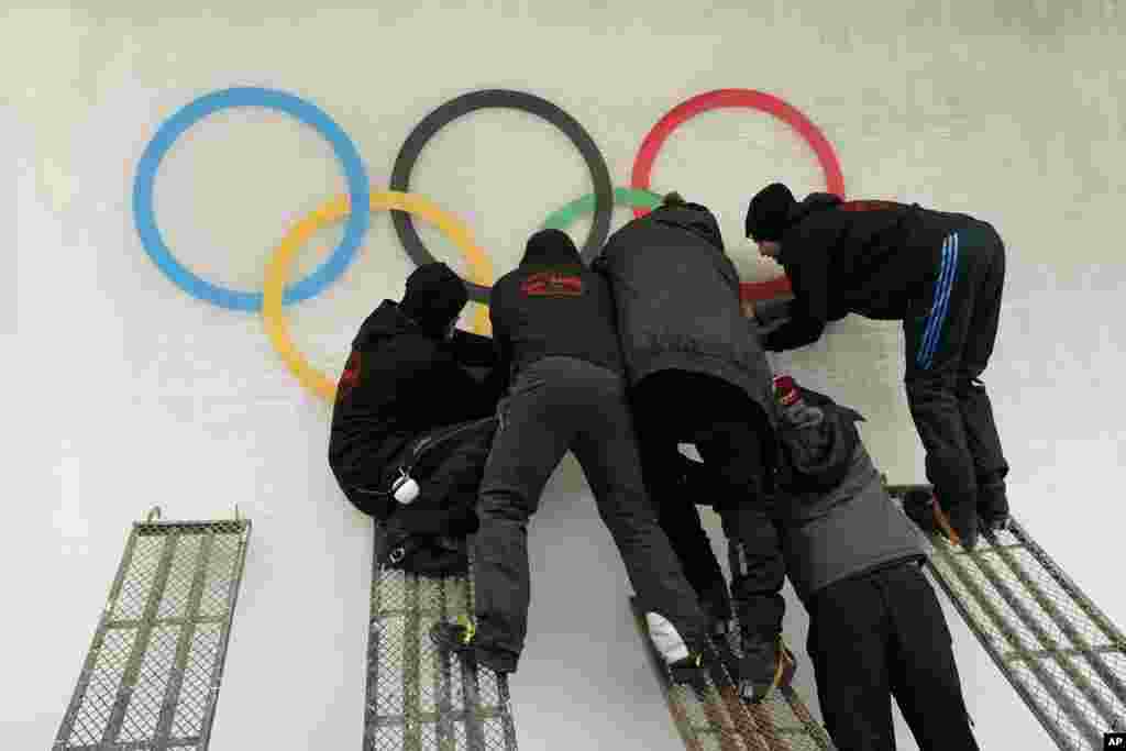 Ice makers place a cutout of the Olympic rings on the track at the Yanqing National Sliding Center, Jan. 28, 2022.
