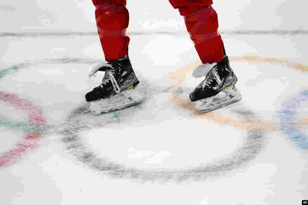A member of the China men&#39;s hockey team skates across the Olympic rings during a practice session at the National Indoor Stadium, Feb. 1, 2022.