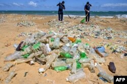 Polisi dari Divisi Perlindungan Lingkungan ikut ambil bagian dalam upaya pembersihan pantai dalam rangka Hari Lingkungan Hidup Sedunia PBB di Gunung Lavinia di pinggiran Kolombo, 5 Juni 2020. (Lakruwan WANNIARACHCHI / AFP)
