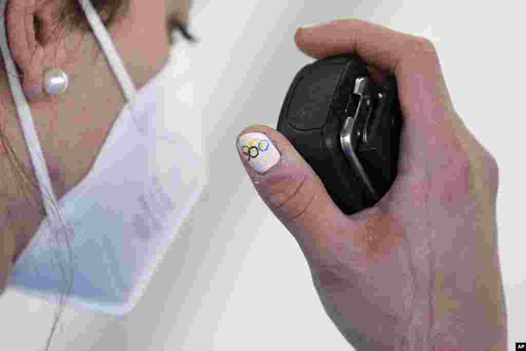 The Olympic rings are seen on the nails of Andrea Voetter of Italy as she talks via radio after a crash during a women&#39;s luge training run, Feb. 6, 2022.