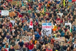 Demonstrators hold up posters at a climate change rally in Erfurt, Germany, Sept. 27, 2019.