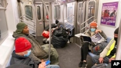 Tampak tidak semua penumpang kereta api bawah tanah di Kota New York menggunakan masker ketika menggunakan transportasi tersebut pada 28 Januari 2022. (Foto: AP/Ted Shaffrey)