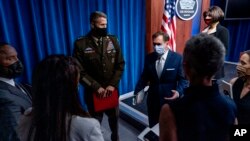 FILE - Pentagon spokesperson John Kirby, center right, speak to reporters as they depart a briefing at the Pentagon, near Washington, Aug. 25, 2021. 