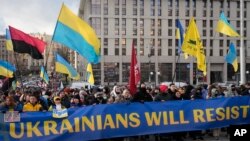 Warga Ukraina berdemo di pusat Kota Kyiv menentang kemungkinan peningkatan ketegangan antara Rusia dan Ukraina, Sabtu, 12 Februari 2022. (Foto: Efrem Lukatsky/AP Photo)
