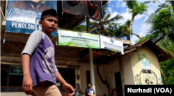 Seorang anak di Wadas melintas di depan posko perlawanan warga. (Foto: VOA/Nurhadi)