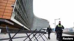 Belgian police officers patrol outside the EU institutions buildings ahead of a potential protest against coronavirus disease (COVID-19) restrictions called "Convoi Europeen de la Liberte 2022" ("European Freedom Convoy 2022"), in Brussels, Feb. 14, 2022.